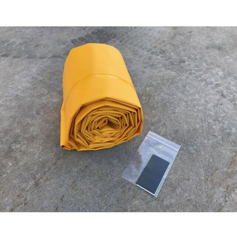 Rolled yellow flood barrier beside a clear accessory bag