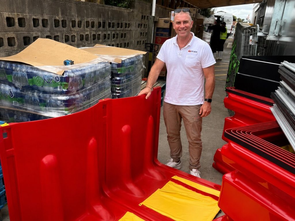 Allan McLean smiling beside red FloodBloc barriers at Mount Albert New World