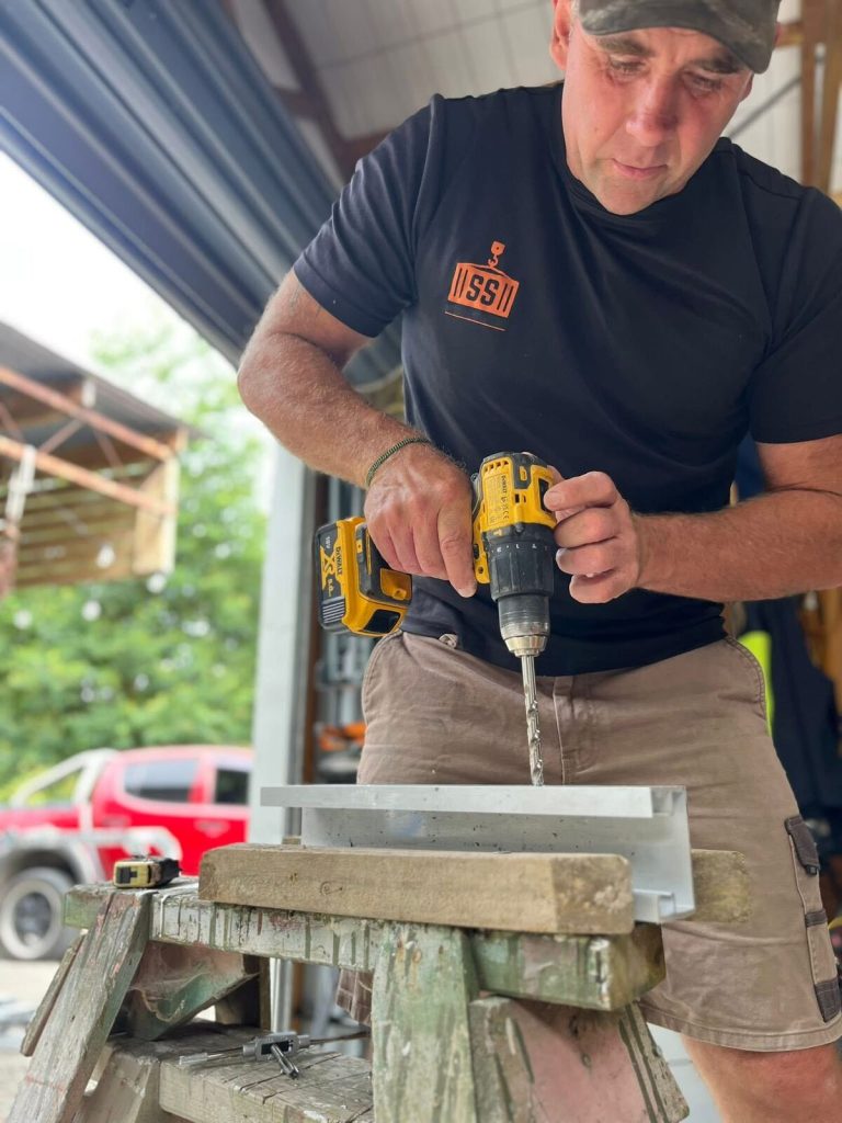 Drilling an aluminium FloodShield component during preparation for residential supply