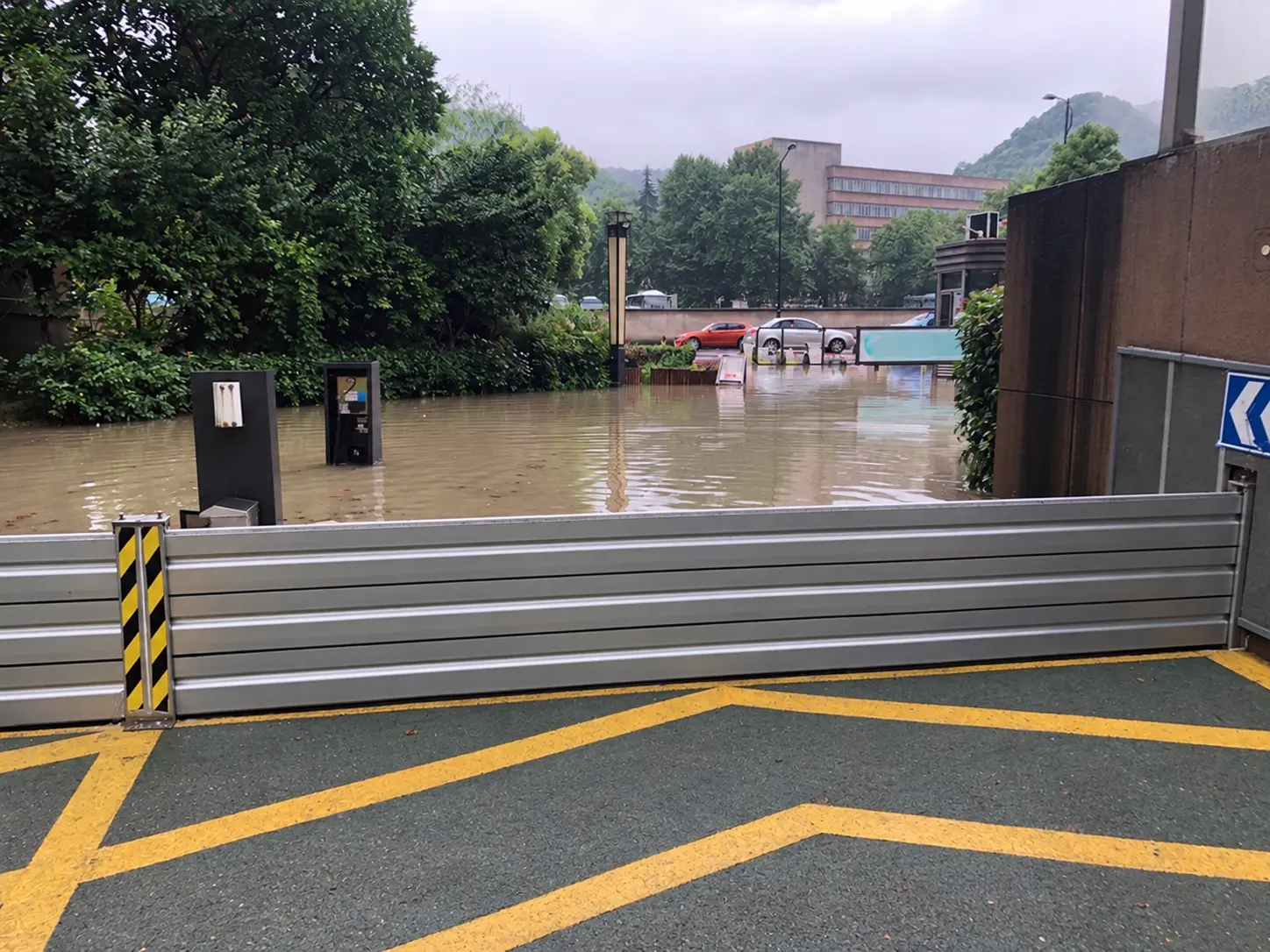 Aluminium FloodShield barrier holding back floodwater with a dry protected area in the foreground