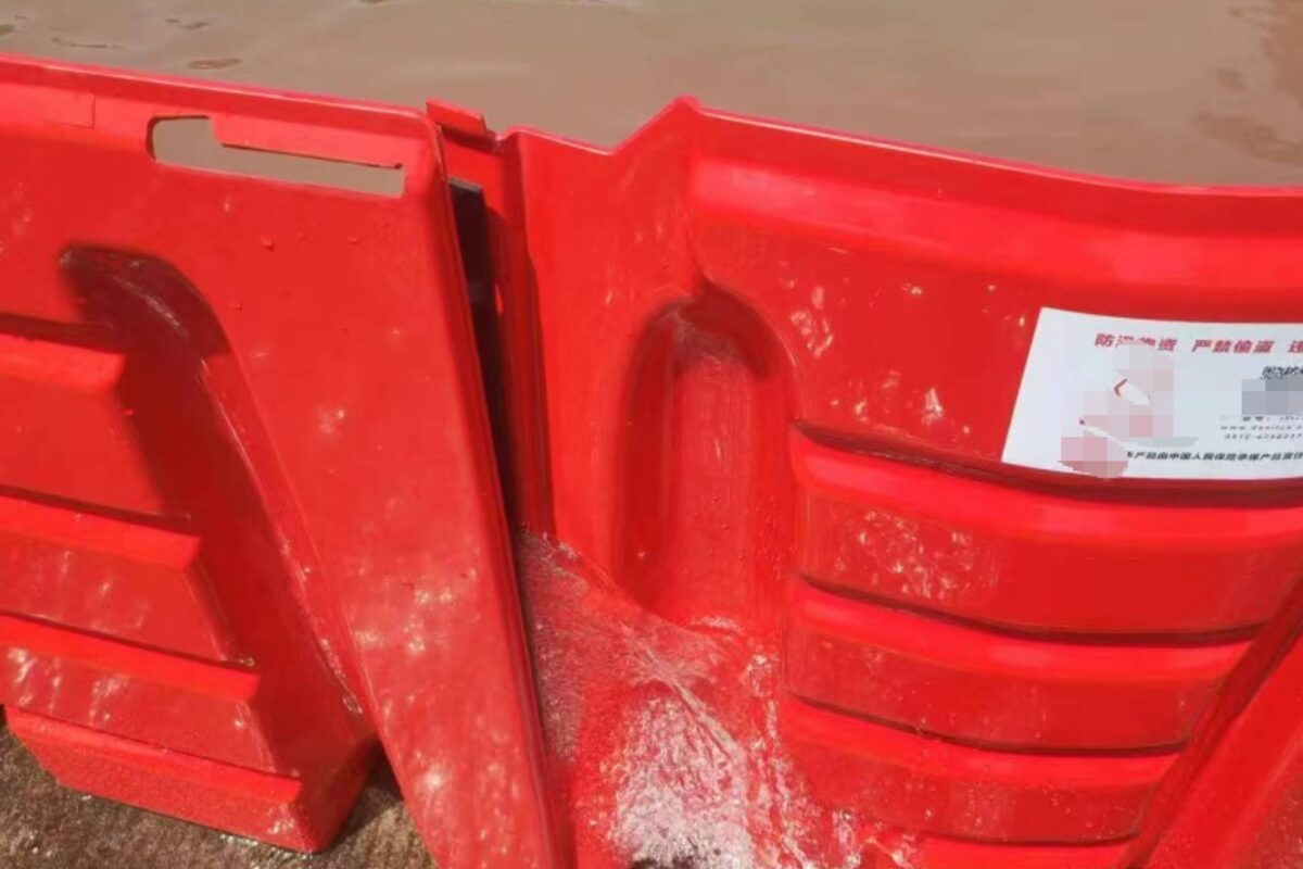 Red modular flood barrier holding back water